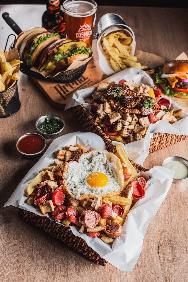 Hearty meal with fries, eggs, sausages, and burgers.